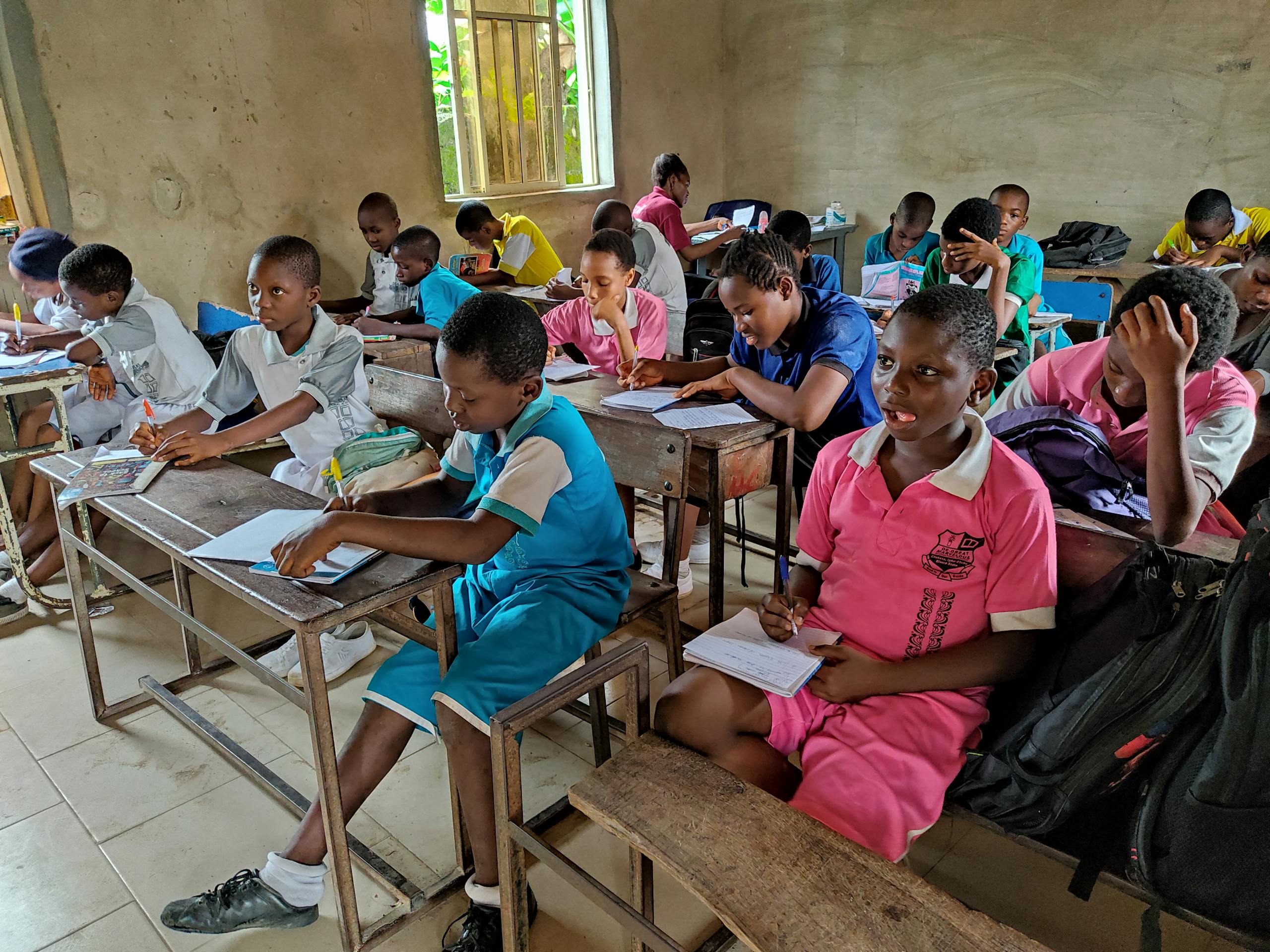 Children studying attentively in a classroom in Igbo-Etche, Nigeria, showcasing active learning.